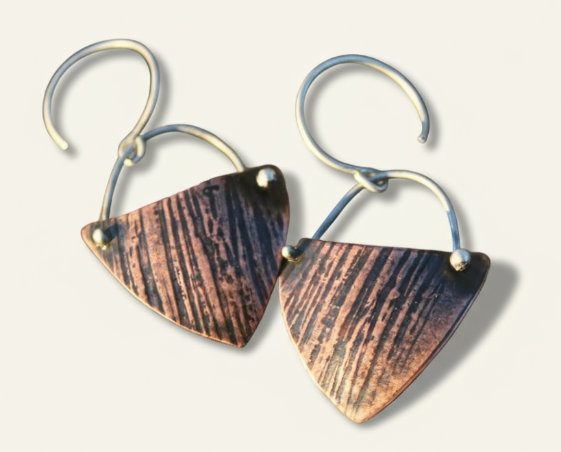 Copper kite shield earrings with raw silk texture, silver forged in place details, and silver earwires.