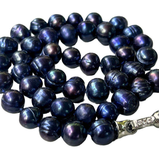 String of dark blue 8mm peacock pearls with 18k white gold plated clasp on a white background
